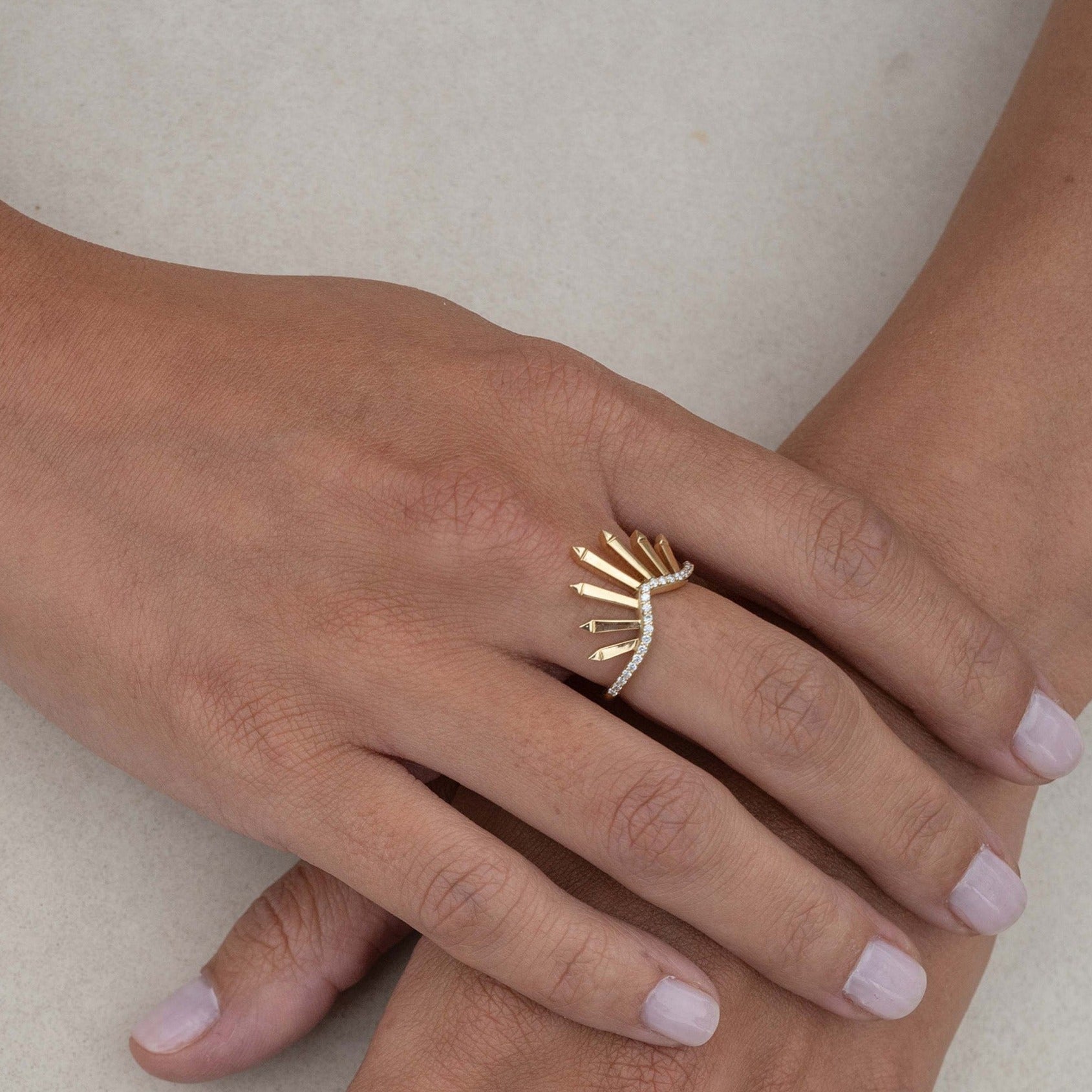 Yellow Gold Ring: Featuring radiant sunburst motifs adorned with diamonds, showcased on hand model.