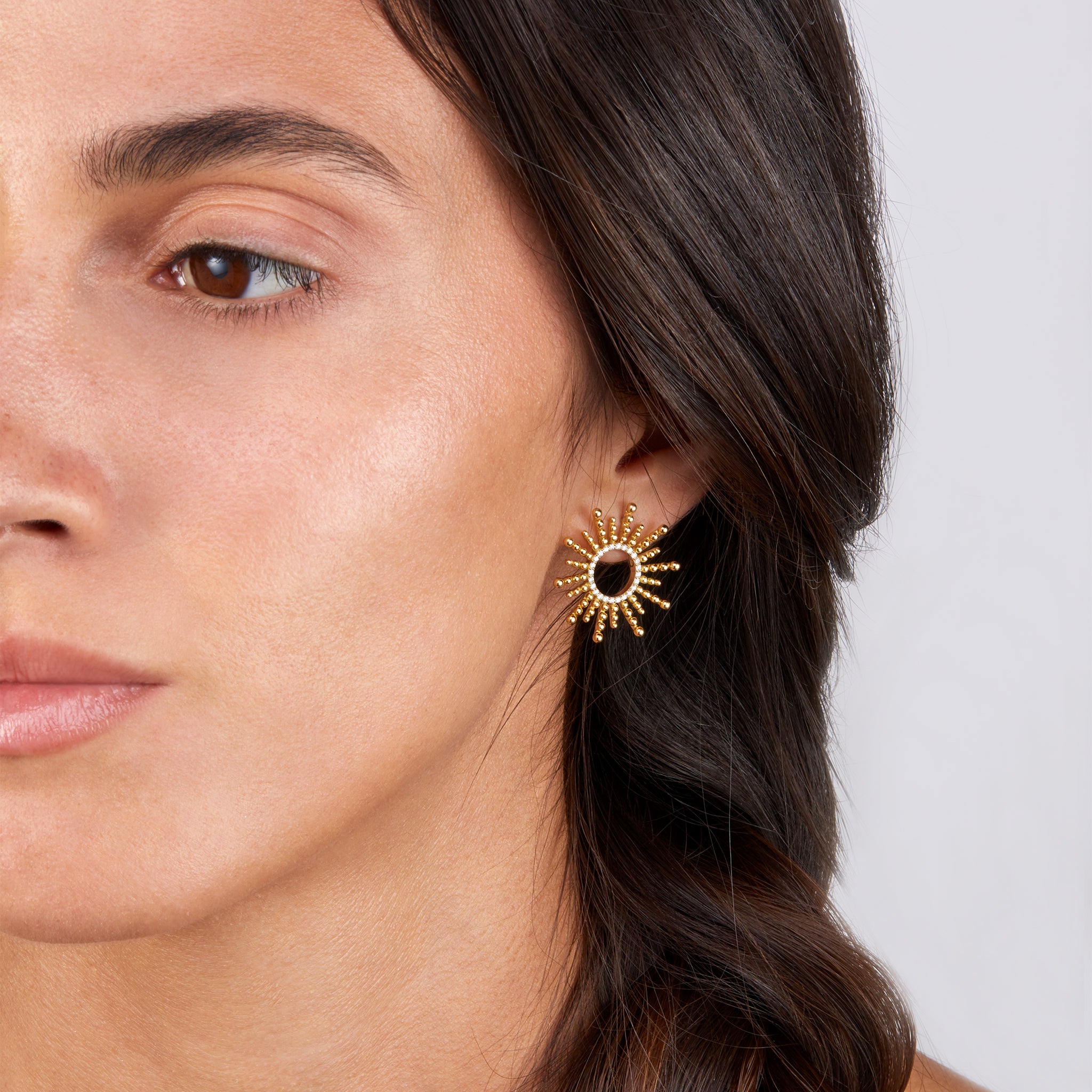 Sea urchin-inspired yellow gold earrings with diamonds, showcased on model