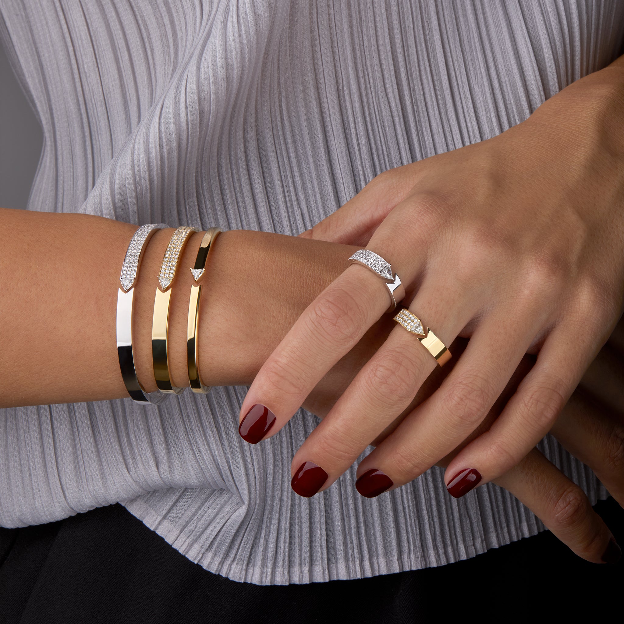 Bangles and rings displayed on hand model. 