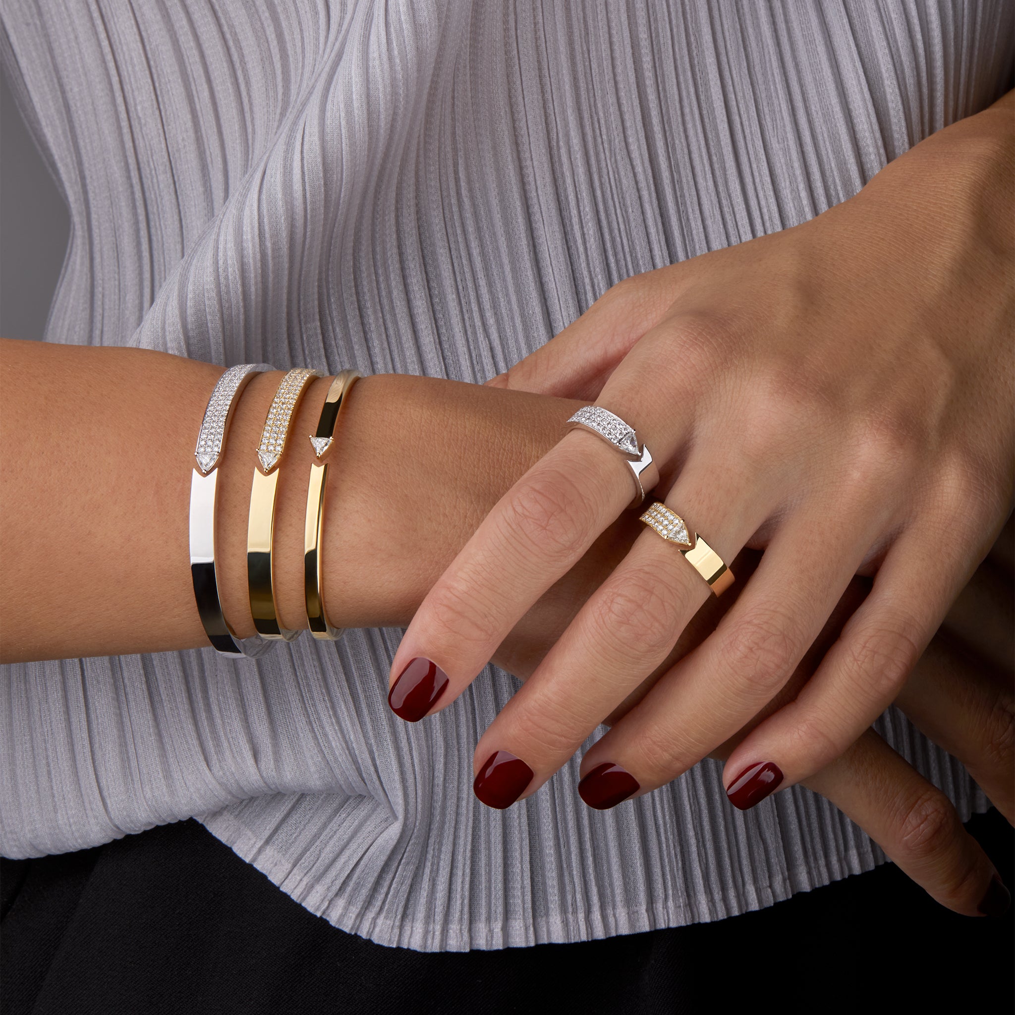 Stellar Standstill bangle and matching rings in yellow and white gold featuring diamonds  displayed on hand model. 