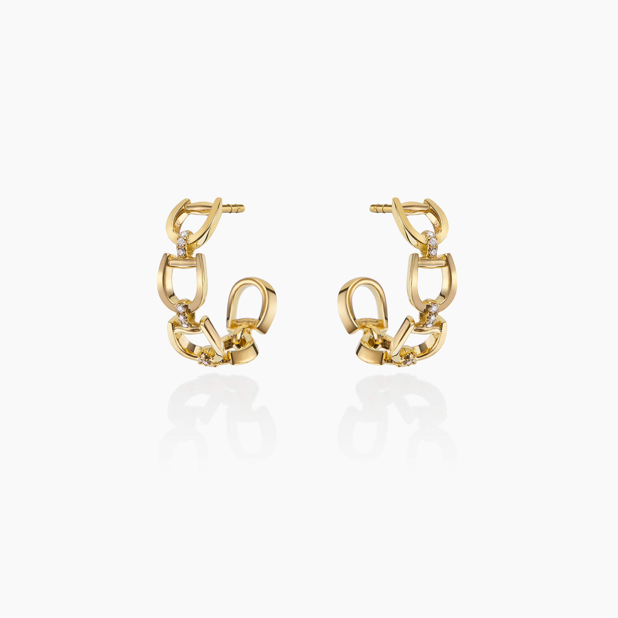 Fulanda Everyday Horsebit Earrings in yellow gold displayed on an off white background.